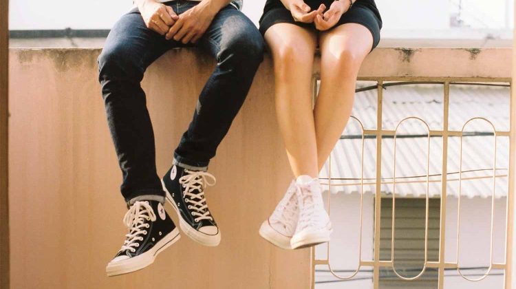 boy girl sitting on ledge converse