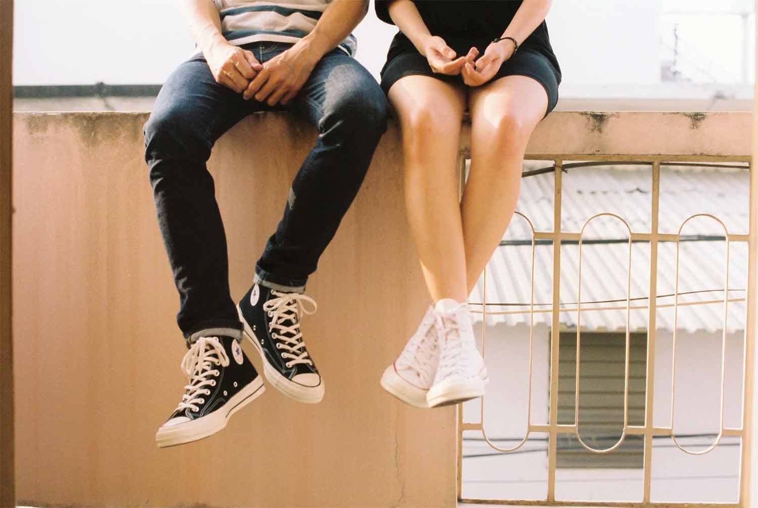 boy girl sitting on ledge converse